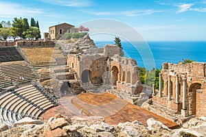 Ruins of the Ancient Greek Theater in Taormina on a sunny summer day with the mediterranean sea. Messina, Sicily, Italy.