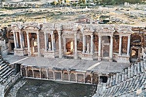 Ruins of ancient Hierapolis Amphi theatre with tourist Pamukkale, Denizili, Turkey. Evening sun