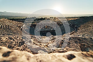 Ruins of ancient Hierapolis Amphi theatre with tourist Pamukkale, Denizili, Turkey. Evening sun