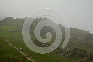 Ruins of the ancient Inca city machu picchu in fog, Peru