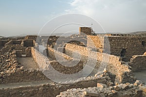 Ruins of ancient Masada fortress in the desert near the Dead Sea. Stone walls of old fortification built on mountain in Israel.