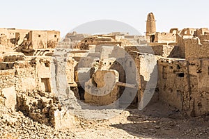 Ruins of ancient middle eastern old town built of mud bricks, old mosque, minaret. Al Qasr, Dakhla Oasis, Western Desert, Egypt.