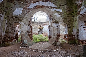 The ruins of an ancient red brick church with remnants of white plaster