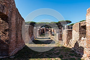 Ruins of ancient street and roman buildings foundations at the archaeological park in Ostia