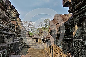 Ruins of an ancient temple in Angkor. The dilapidated walls of the stone gallery