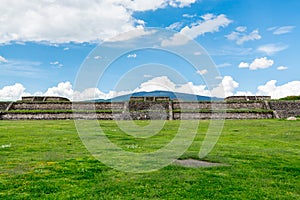 Ruins of the architecturally significant Mesoamerican pyramids and green grassland located at at Teotihuacan, an ancient