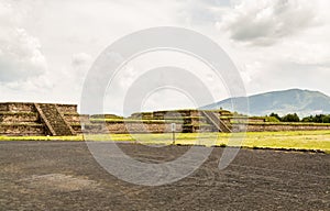 Ruins of the architecturally significant Mesoamerican pyramids and green grassland located at at Teotihuacan, an ancient