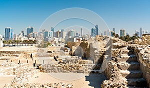 Ruins of Bahrain Fort with skyline of Manama. A UNESCO World Heritage Site