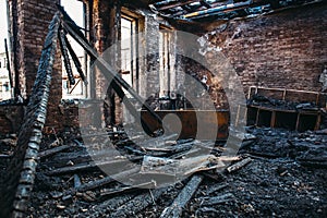 Ruins of burned brick house after fire disaster accident. Heaps of ash and arson, burnt furniture