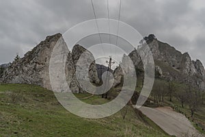 Ruins of castle Vrsatec in spring dark cloudy day with path and poles