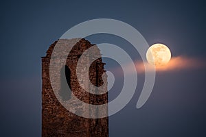 The ruins of the church tower and the moonrise in full moon