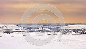 Ruins of Corfe Castle viewed across snow-covered fields