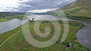 The ruins of historic Kilchurn Castle and jetty on Loch Awe