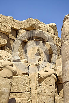 Ruins of Karnak Temple complex with statues, sculptures and columns carved with ancient Egyptian hieroglyphs and symbols