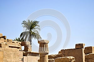 Ruins of Karnak Temple complex with statues, sculptures, pillars and columns carved with ancient Egyptian hieroglyphs and symbols