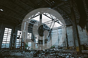 Ruins of large hall of abandoned warehouse or factory, consequences of catastrophe, war, hurricane, earthquake