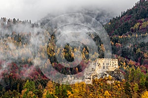 Zřícenina hradu Likava a podzimní les na pozadí