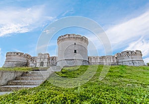 Ruins of medieval old tower of castle with stairs under blue sky in Matera Italy