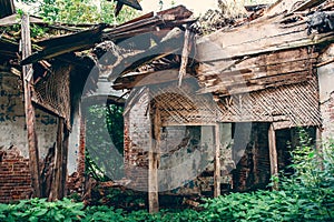 Ruins of old abandoned building room interior inside with fallen roof and overgrown with grass
