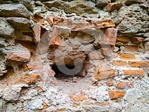 Ruins and old brick wall close up. Broken ancient brick wall with hole size of one brick. Concept destruction background