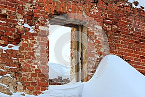 Ruins of old brick wall with window hole