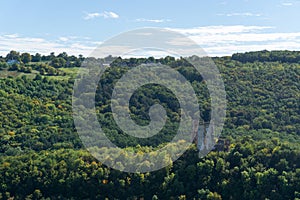 Ruins of the old castle on the hill hugged by autumn forest.