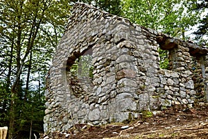 Ruins of an old and forgotten lodge in a field captured during the daytime