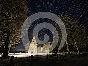 The ruins of an old medieval church with comet mode star trails.