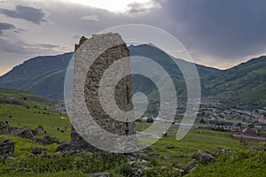 The ruins of an old Ossetian tower against the background of the village of Verkhny Fiagdon. North Ossetia-Alania