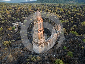 Ruins at Paricutin Volcano situated on a rocky landscape surrounded by lush greenery