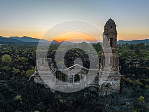 Ruins at Paricutin Volcano situated on a rocky landscape surrounded by lush greenery