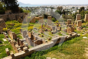 Ruins of Punic Quarter in Carthage against backdrop of modern city photo