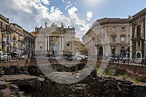 Ruins of the Roman Amphitheater at the Stesicoro Square with San Biagio Church on background - Catania, Sicily, Italy photo