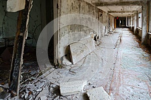 Ruins of school corridor in abandoned building, dead ghost town Pripyat in Chernobyl alienation zone, Ukraine