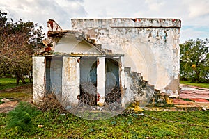 Ruins and stairs of a single story demolished building in a meadow field