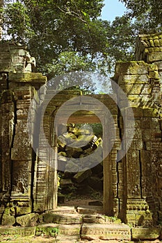 Ruins of a stone doorway at Ta Prohm temple, located in the Angkor Wat complex near Siem Reap, Cambodia.