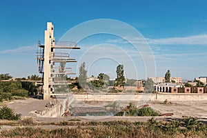 Ruins of swimming pool with a diving tower reminiscent of Chernobyl