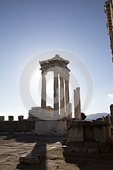 Ruins of the Temple of Trajan the ancient site of Pergamon. Izmir, Turkey. Ancient city columns with the sun in the background.