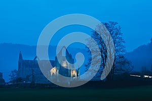 The ruins of Tintern Abbey lit up on a atmospheric winters evening. Wye Valley. UK