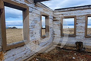 The ruins of a wooden house on the sandy beach