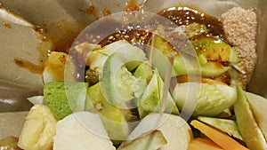 Rujak buah or indonesian mixed fruit salad, served with spicy brown sugar sauce and ground peanuts photo