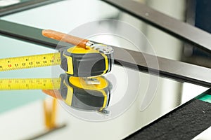 A ruler and a glass cutter, They lie on the mirror, The glass industry and the glaziers tools