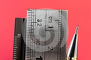 Rulers and mechanical pencil macro image in red background.