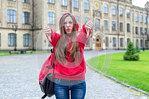 Rules break concept. Photo of striking expressing her indignation teen rebel hipster in hoodie showing fingers down symbol