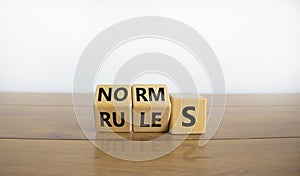 Rules or norms symbol. Turned cubes and changed the word `norms` to `rules`. Beautiful wooden table, white background, copy sp