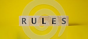 Rules symbol. Wooden cubes with word Rules. Beautiful yellow background. Rules concept. Copy space