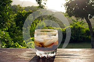 A rum and coke on a porch railing in the northern grenadines