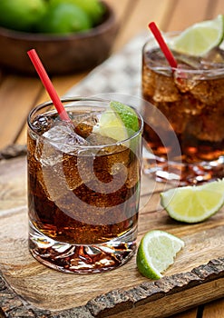 Rum and cola cocktail with ice and lime