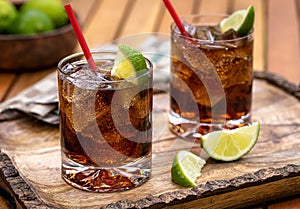 Rum and cola cocktail with ice and lime