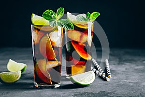 Rum and Cola Cuba Libre ice cold drink cocktail with lime and mint